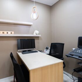 はい、この画像は医療施設の診察室を示しています。コンピューターと医療機器が設置されており、患者の診断や治療に使用されているようです。整理された空間で、患者の皆様が安心して診察を受けられる環境が整えられていると感じられます。医療従事者の方々が丁寧なケアを提供されていることが伺えます。