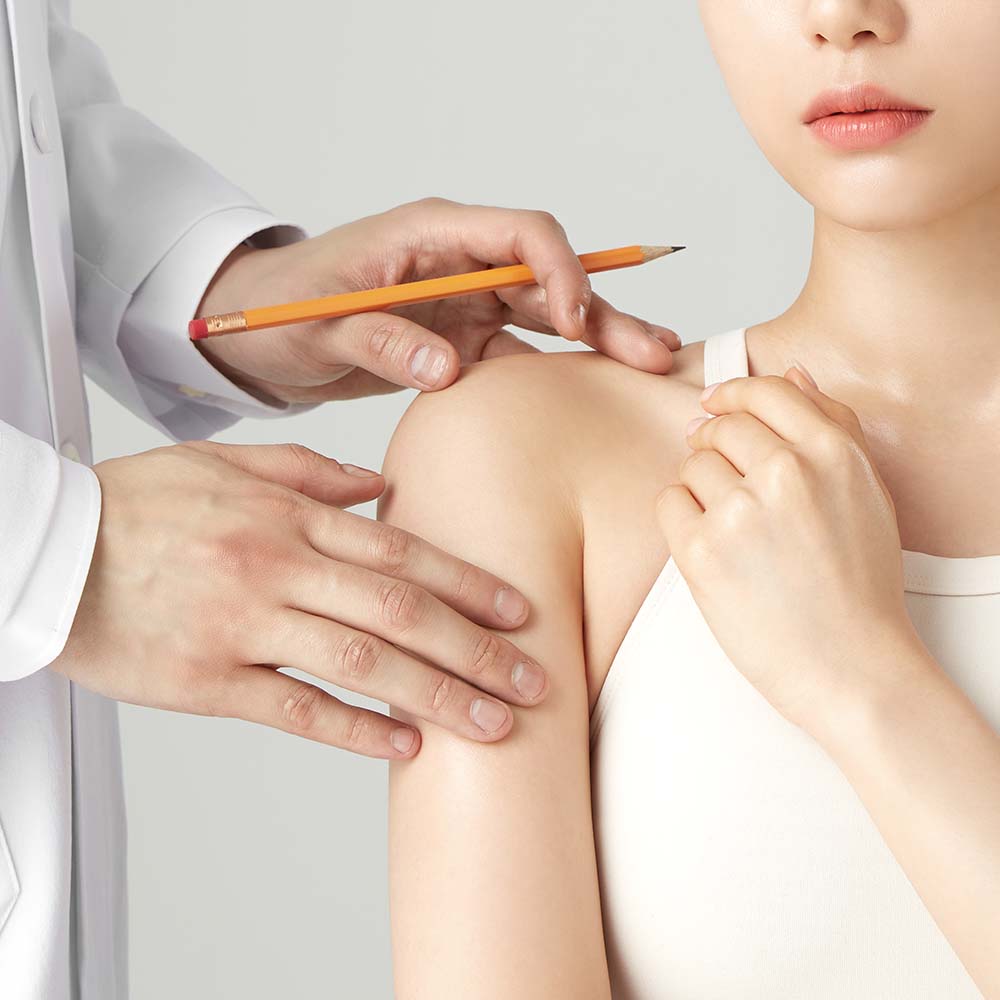 Dermatologist examining patient skin for treatment consultation