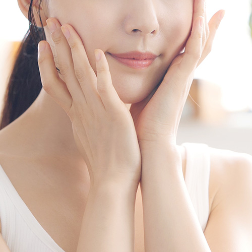Close-up of a woman touching her face for sharper face shape and more supple skin