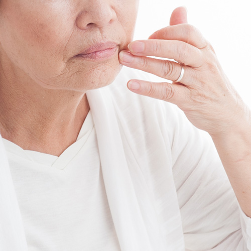 Concerned woman touching her buccal fat and marionette lines