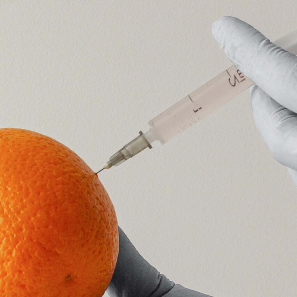 Skin rejuvenation injection procedure demonstrated on an orange.