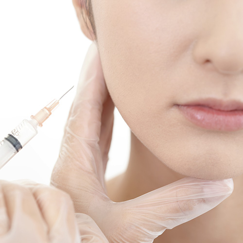 Non-surgical facial contouring procedure with a needle injection near the jawline for defined features