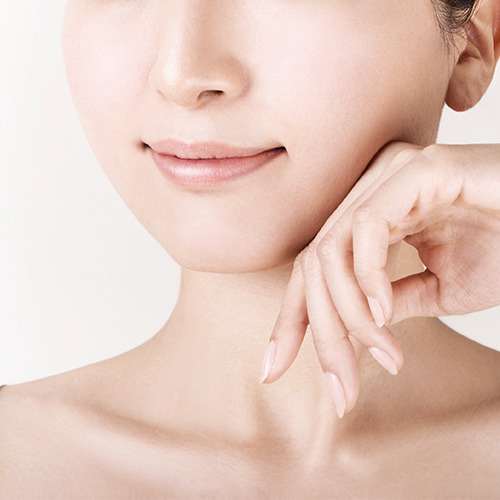 Close up of a woman's face and hand with smooth, youthful skin highlighting long-lasting results in skin care.