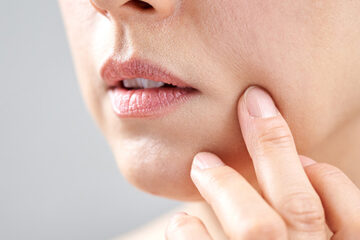 Close-up of a woman's face with smooth, hydrated skin being gently touched, emphasizing skin regeneration and hydration