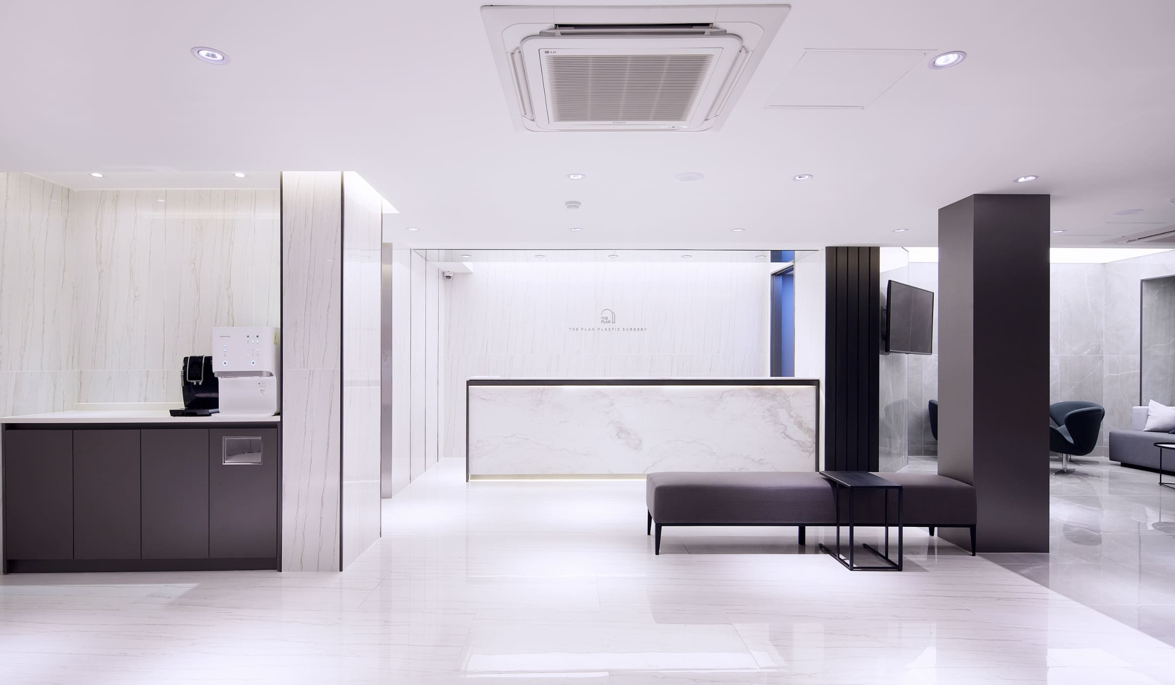 Modern and clean interior of a plastic surgery clinic reception area with white walls and contemporary design.