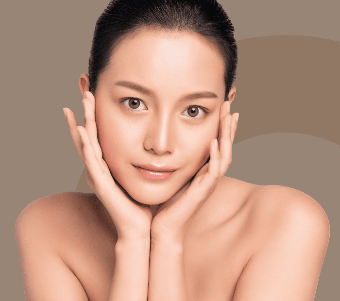 女性が美しく整った顔立ちで、柔らかい微笑みを浮かべながら両手で顔を支えている写真。肌が滑らかで、額や眉のラインが引き締まっており、リフトアップ効果が強調されている。